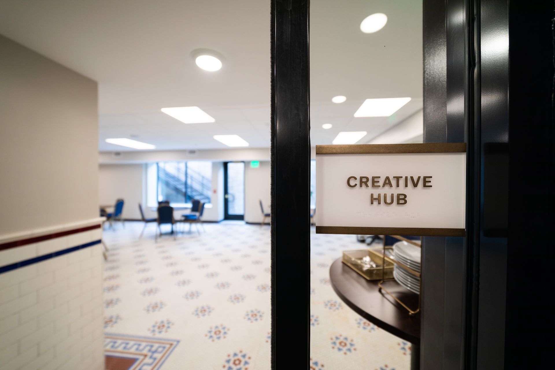 Office hallway with a “Creative Hub” sign and seating area beyond
