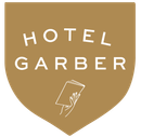 Hotel Garber logo in a gold shield; white text and hand holding papers.