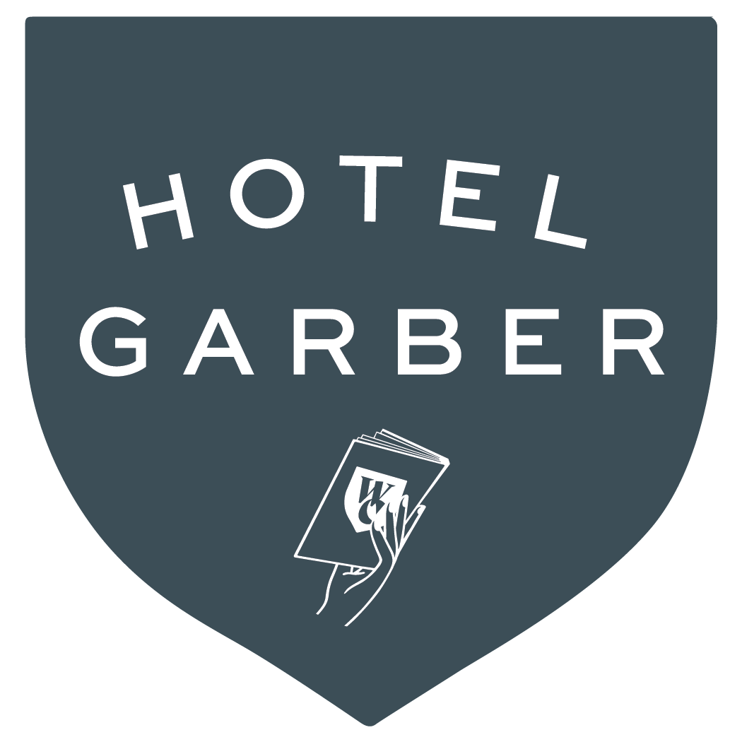 Hotel Garber logo: dark teal shield with white text and a hand holding a stack of cards.