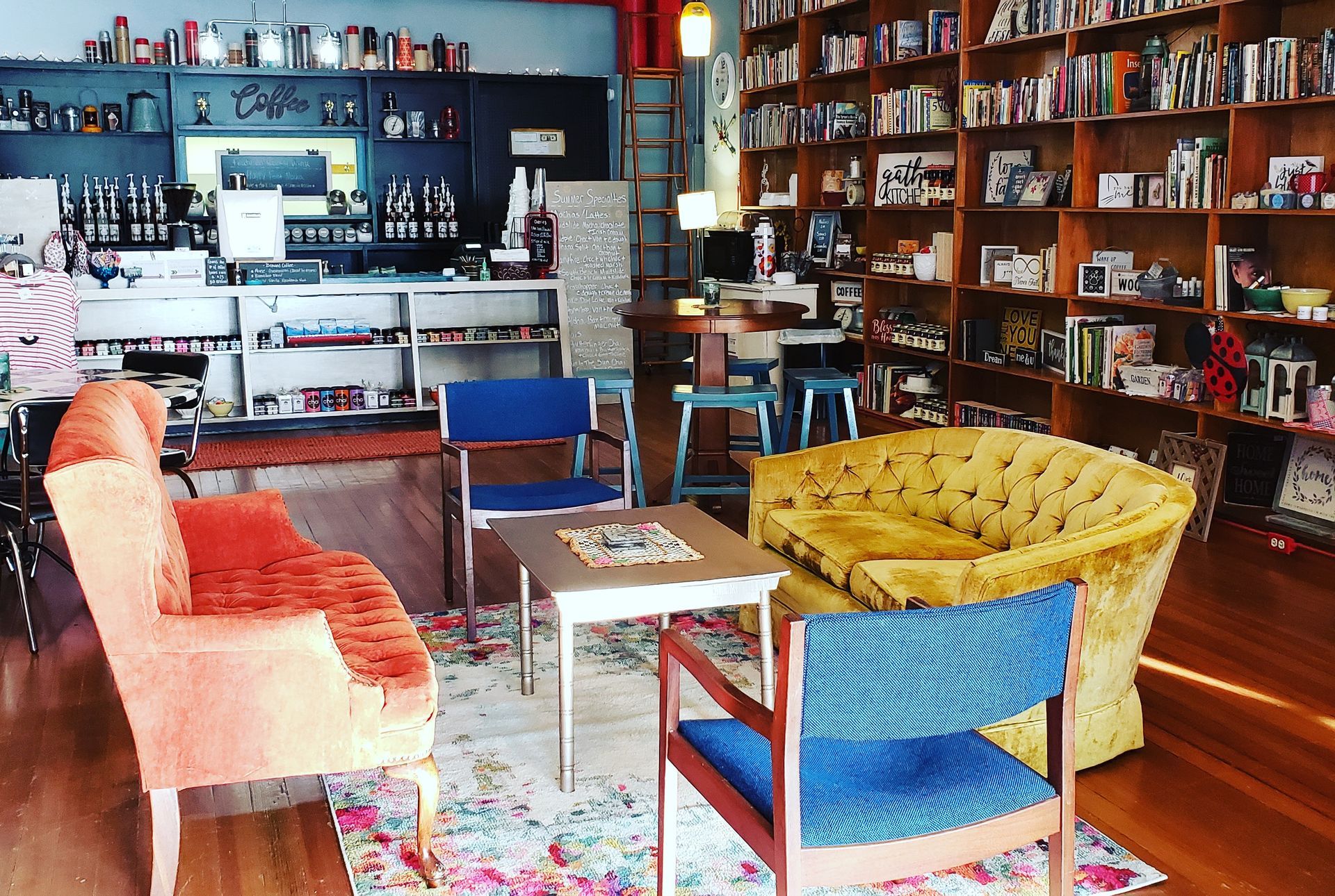 Cozy bookstore interior with coffee bar, bookshelves, vintage furniture, and small tables.