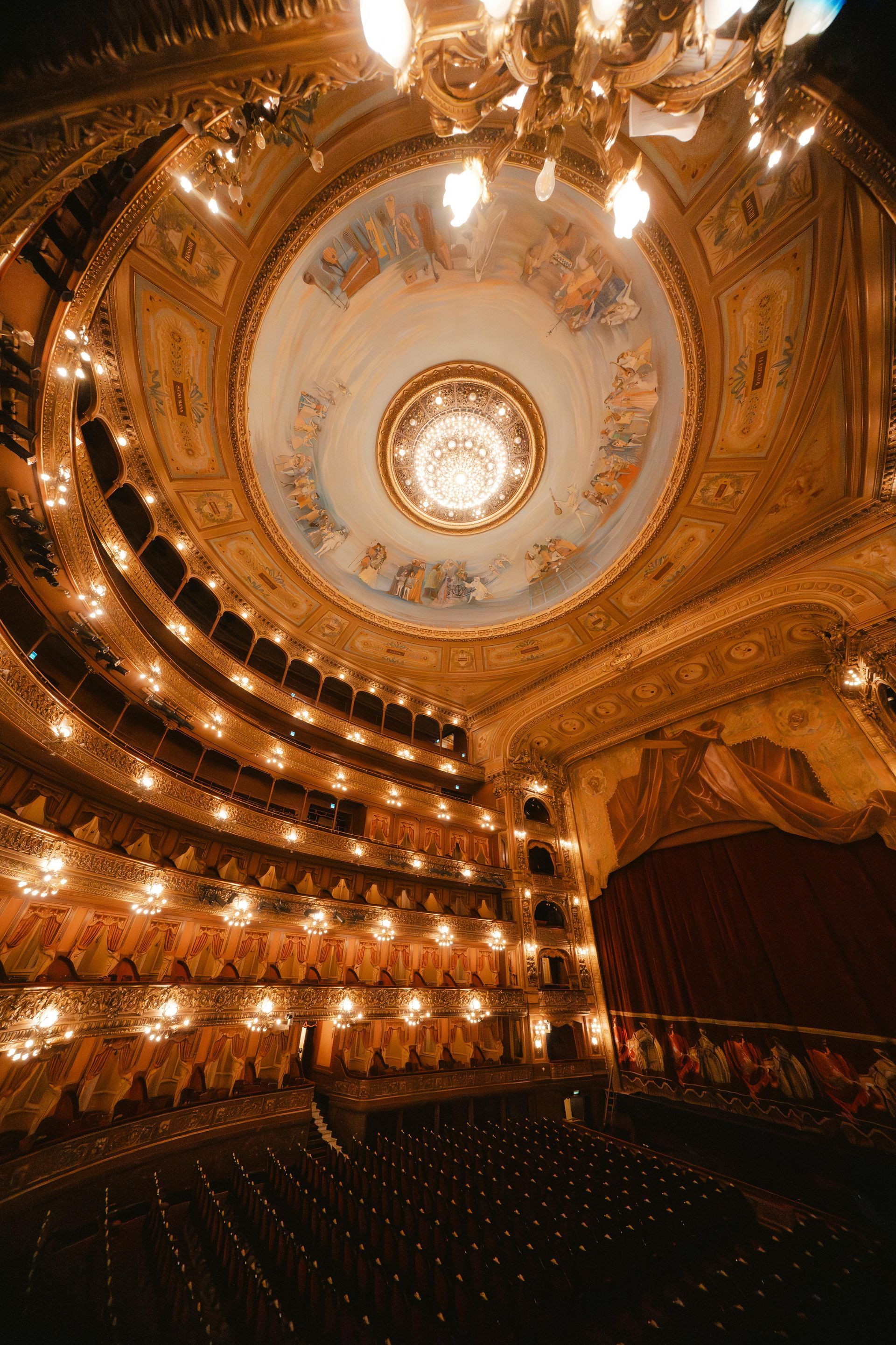 Ornate theater interior with multiple levels of seating and a decorated ceiling.