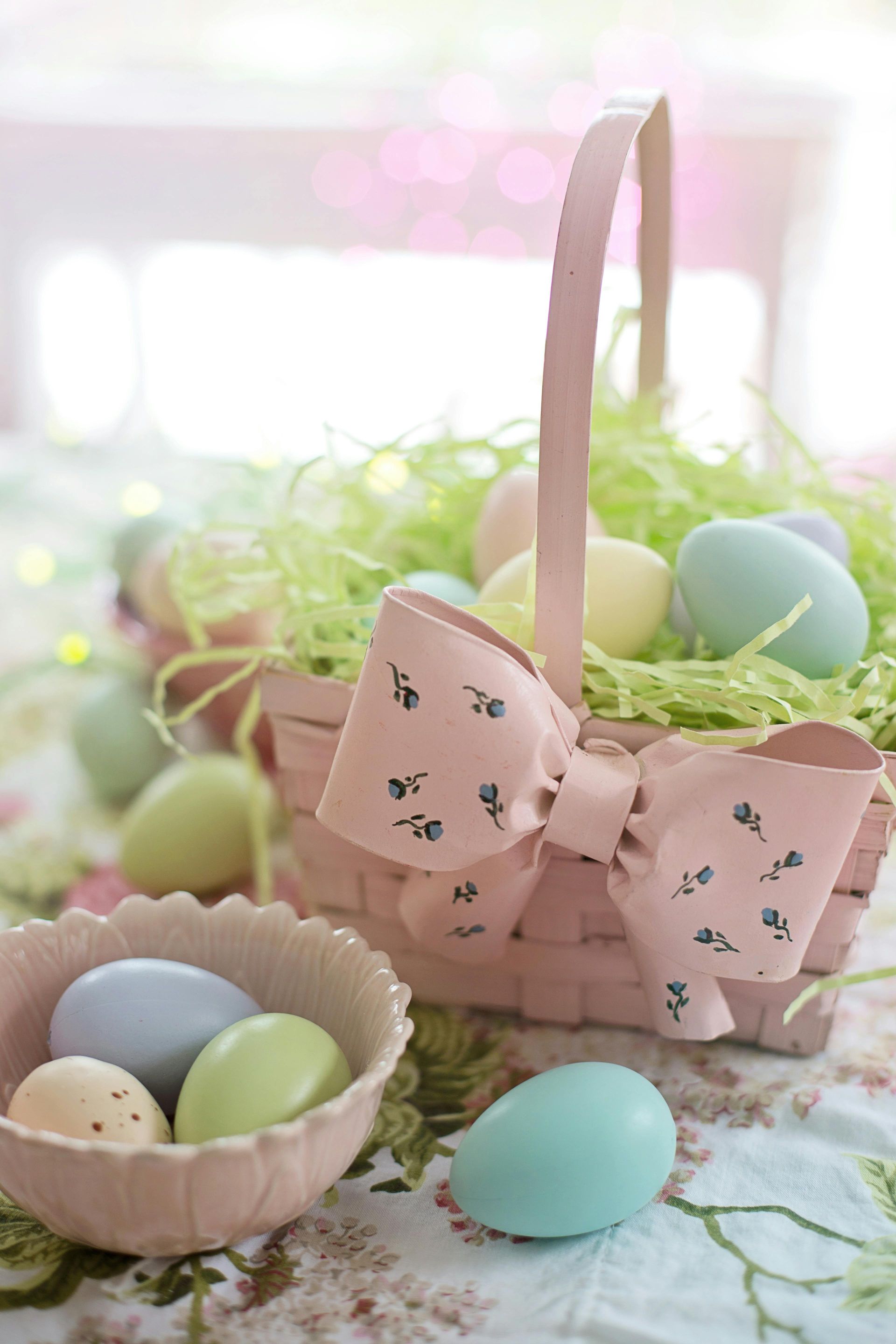 Pastel Easter basket with eggs and a pink bow.