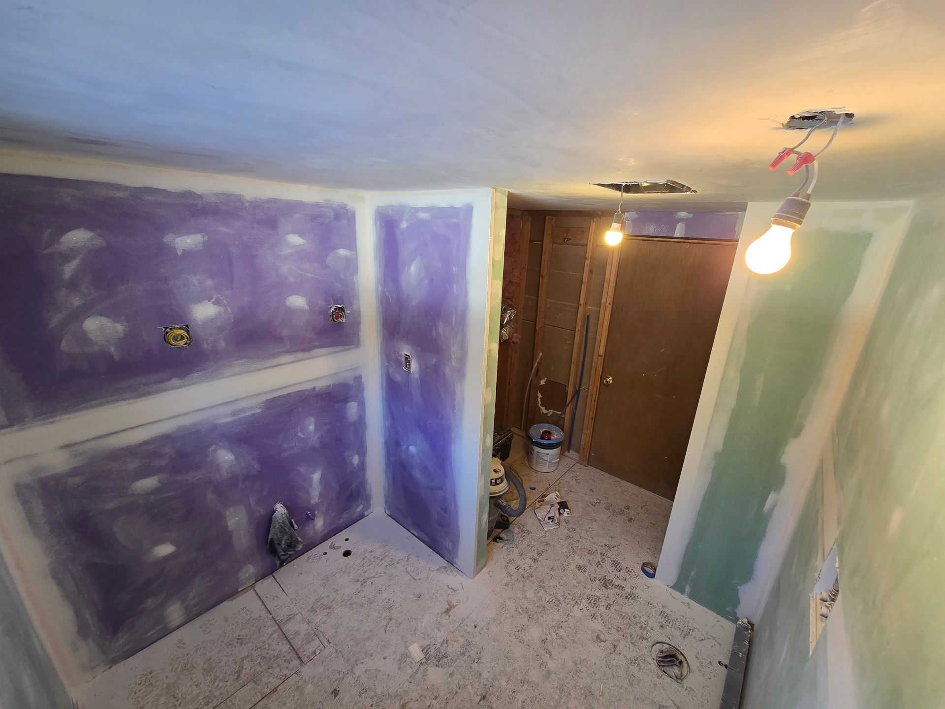 A light green HVAC unit stands in a dimly lit basement next to a water heater and a white washing machine.