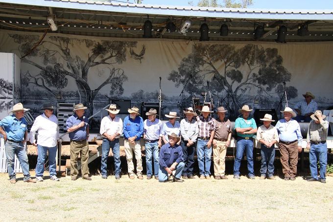 Group of people standing outdoors in front of a mural, posing for a group photo