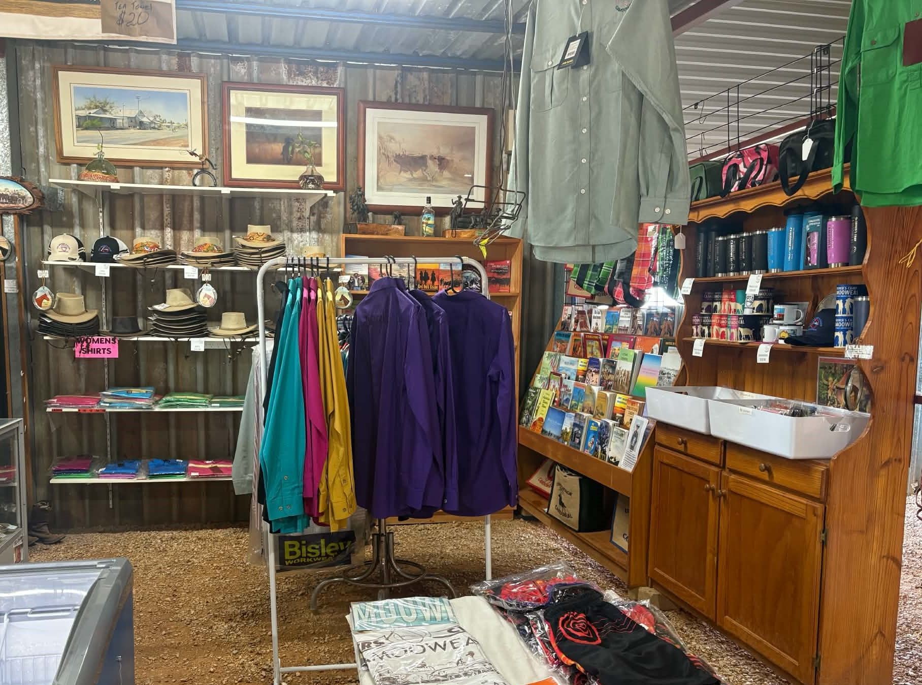 Person standing by tables of handmade leather goods in a rustic market stall