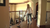 Person vacuuming a hardwood hallway beside a stair railing in a warmly lit home.
