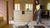 Woman vacuuming a hardwood floor in a bright kitchen and dining area