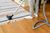 Vacuuming a striped rug on a hardwood floor, with a person standing nearby.