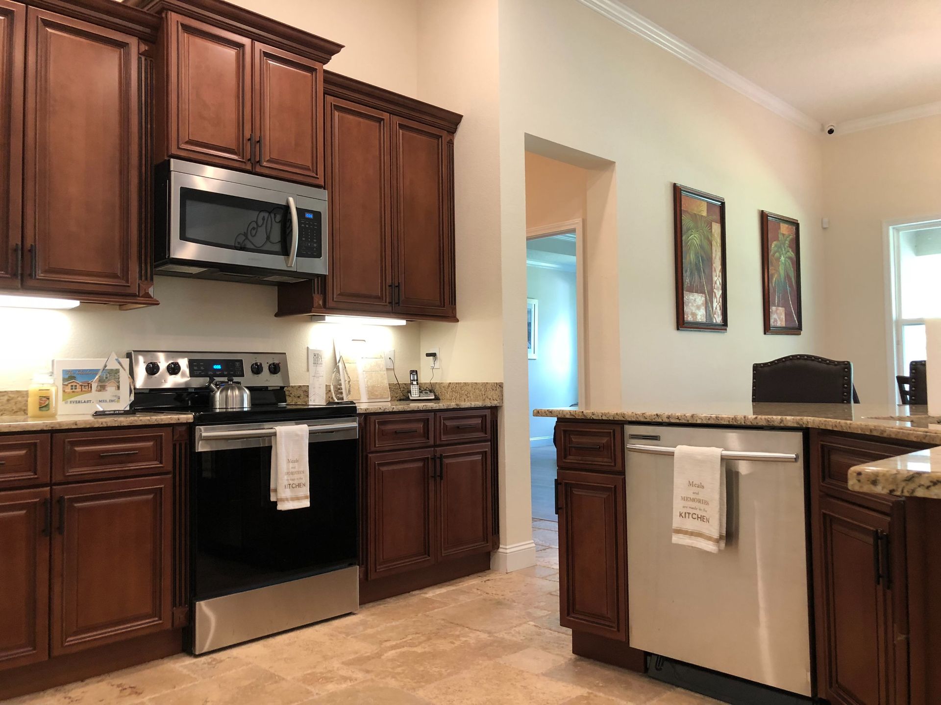 Modern kitchen with dark wood cabinets, stainless appliances, and a breakfast bar in an open living space