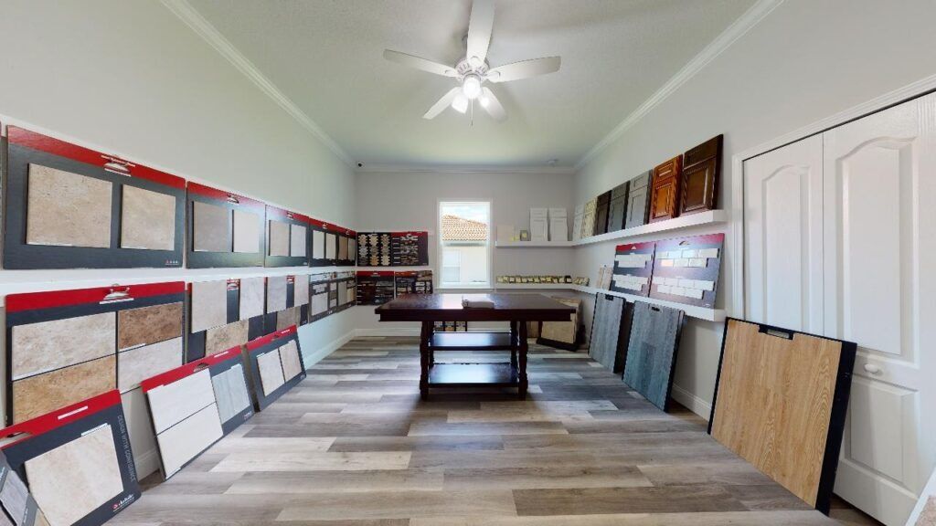 Bright room with display boards, framed samples along the walls, and a table in the center.