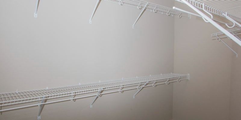 White wire shelving installed along two walls in an empty closet or pantry corner.