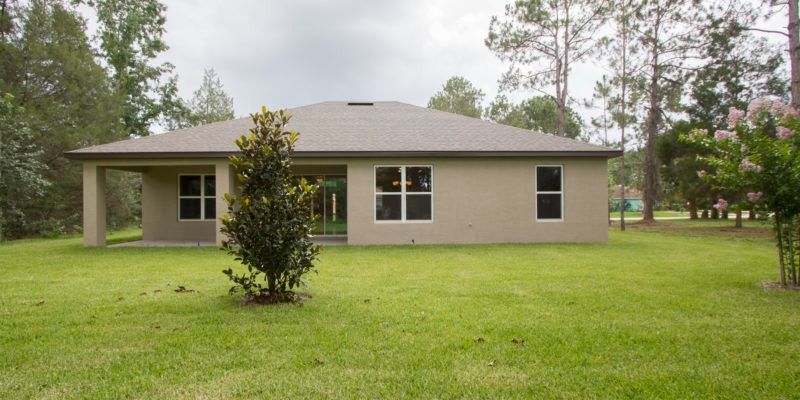 Single-story beige house with a small front porch and large green lawn