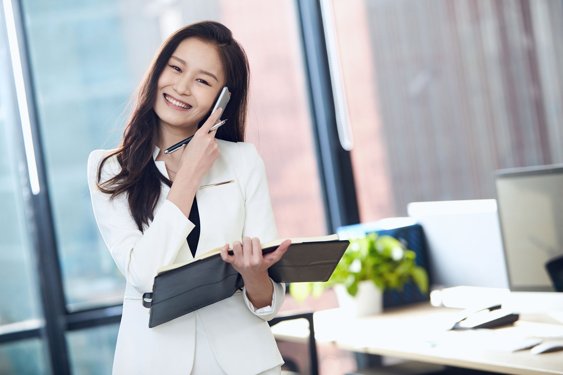 A business person smiling at their desk
