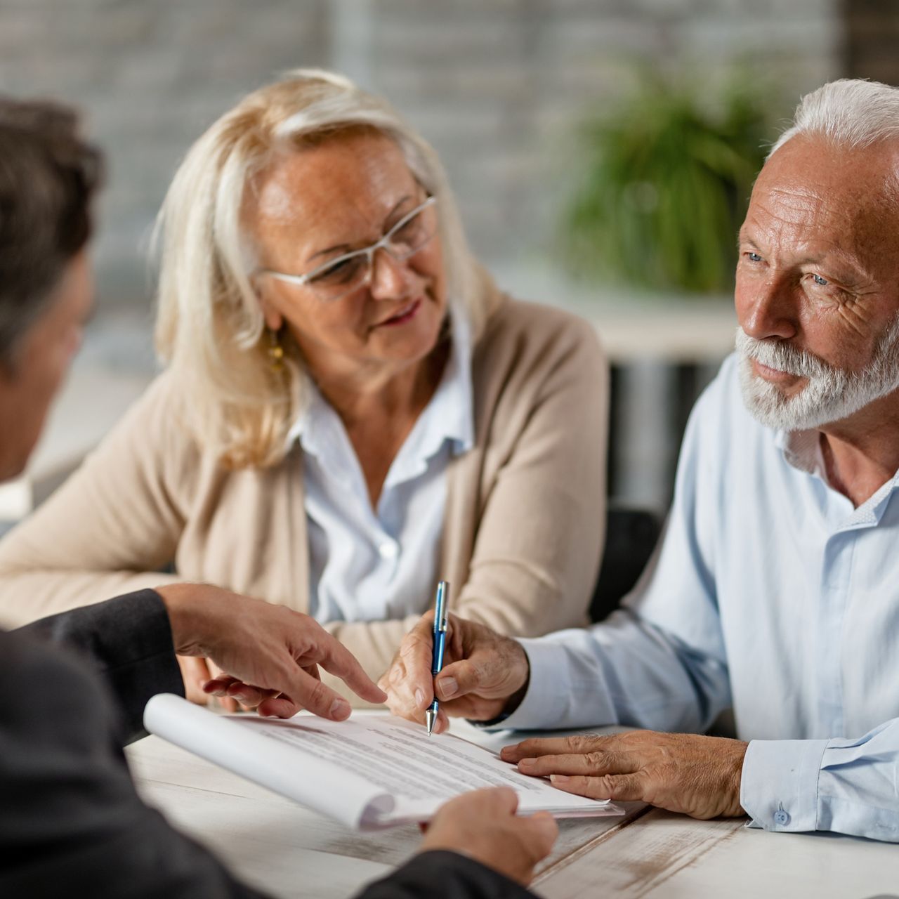 A man and a woman are sitting at a table looking at a piece of paper.