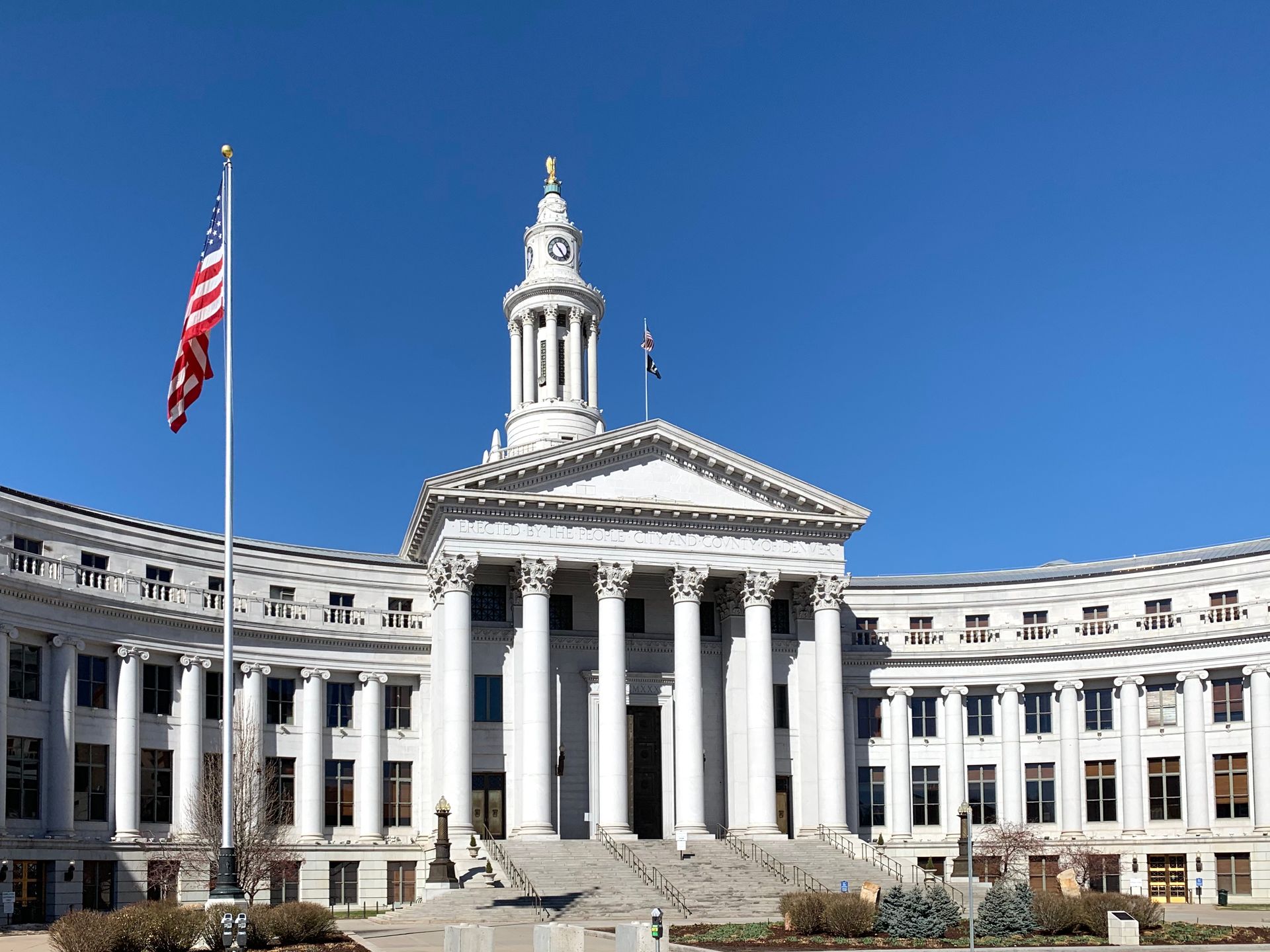 A large white building with columns and a flag in front of it