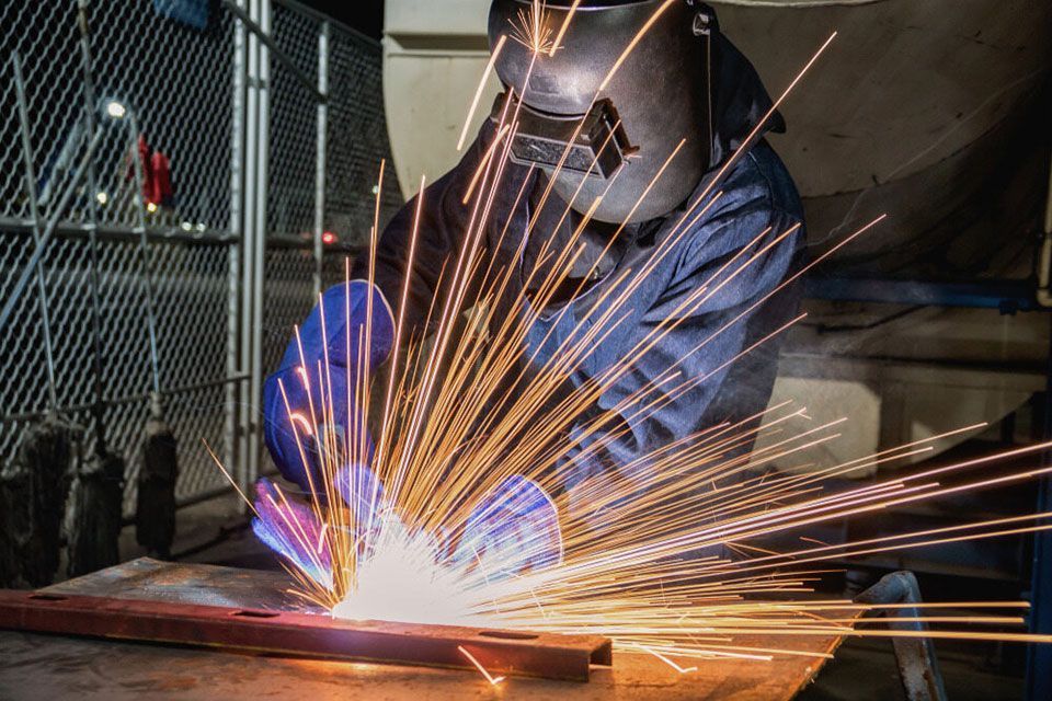 Worker Welding On Metal Bar - Expert Fabrication in Cairns