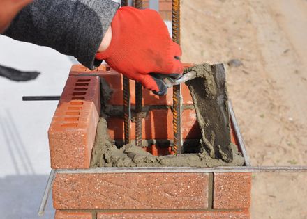 Professional residential masonry contractor installing brick veneer with precision and care. Professional residential masonry contractor installing brick veneer with precision and care.