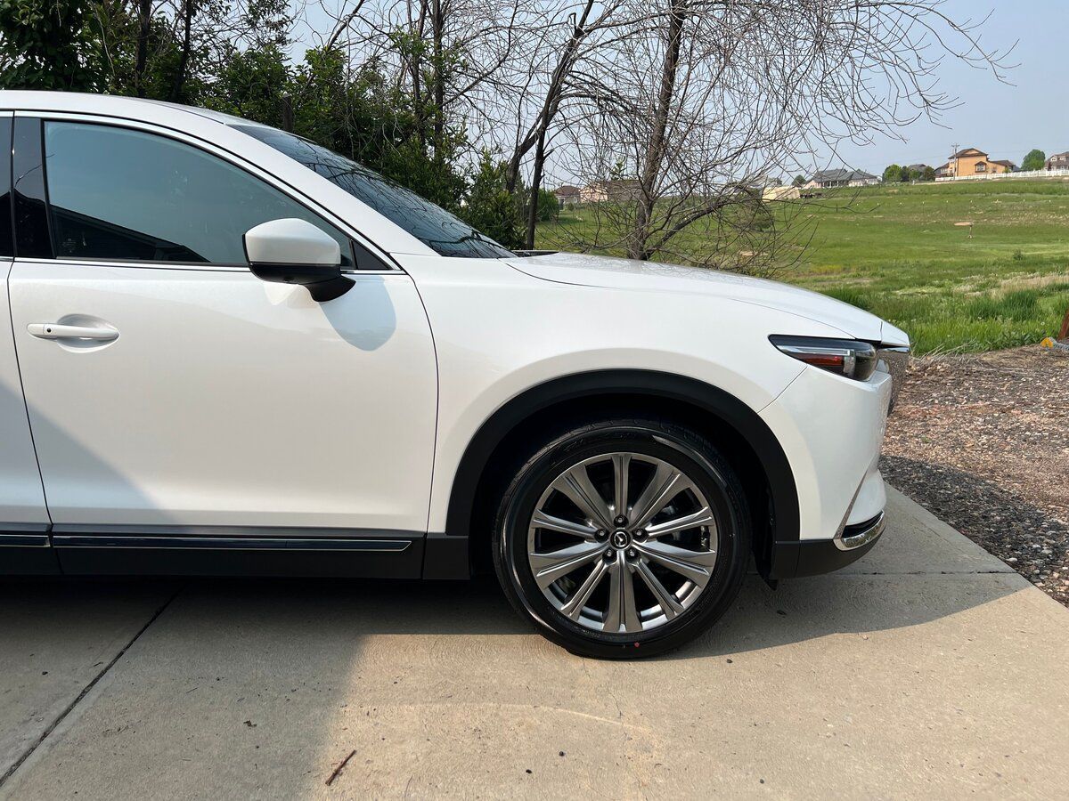A white car is parked on the side of the road.