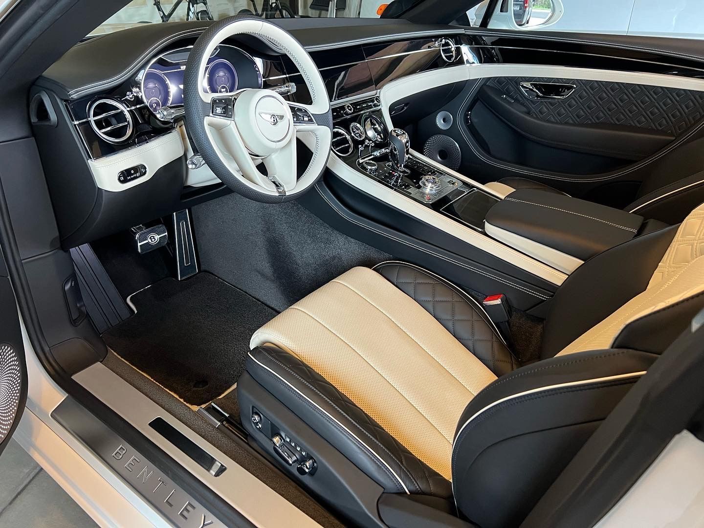 The interior of a bentley car with a steering wheel and seats.