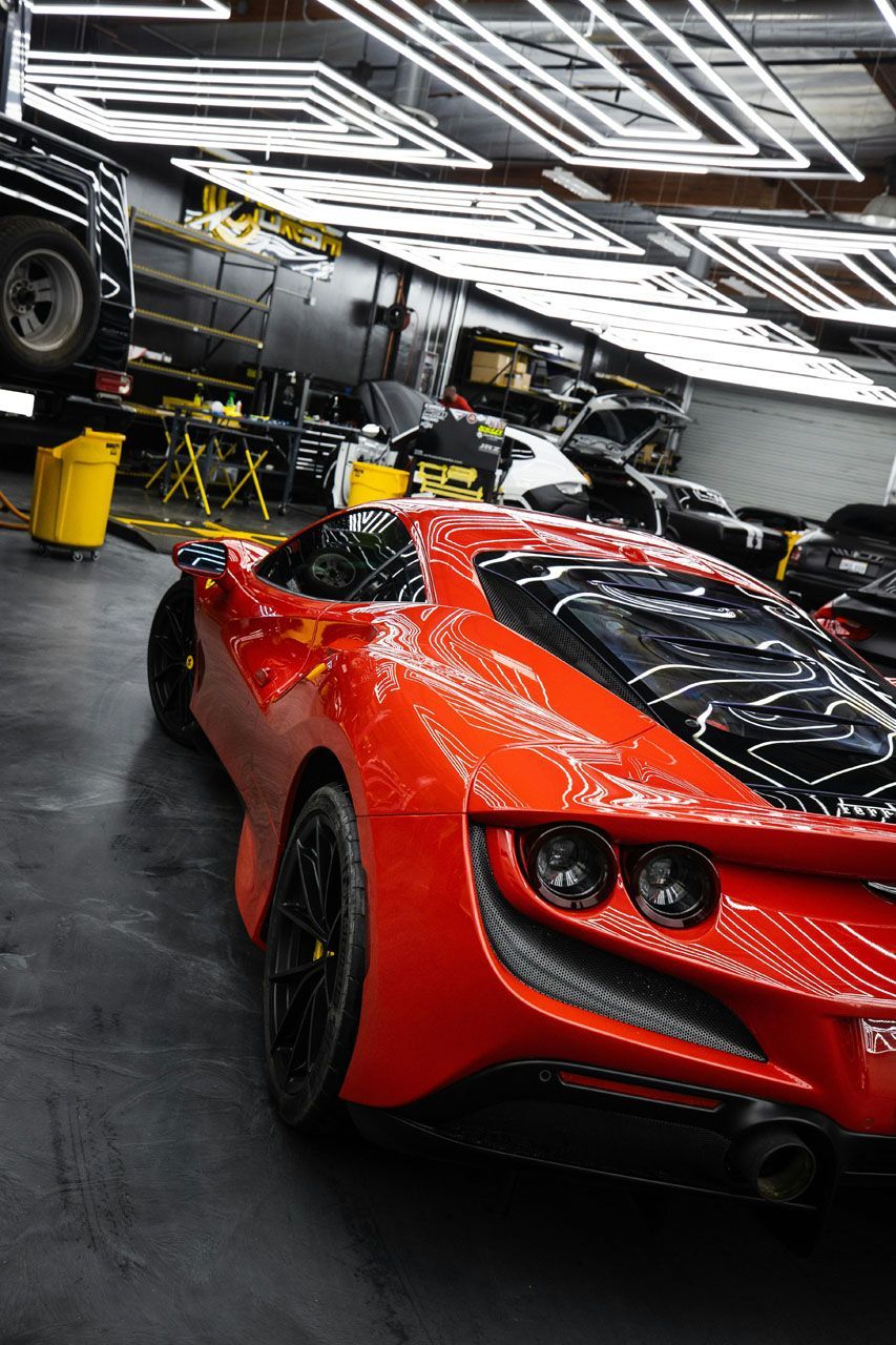 A red sports car is parked in a garage.