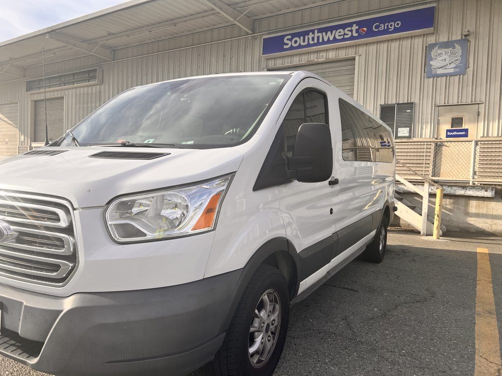 A white van is parked in front of a southwest cargo building.