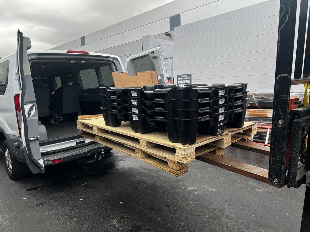 A van is loaded with a pallet of weights and a forklift.