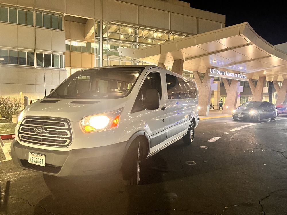 A white van is parked in front of a building at night.