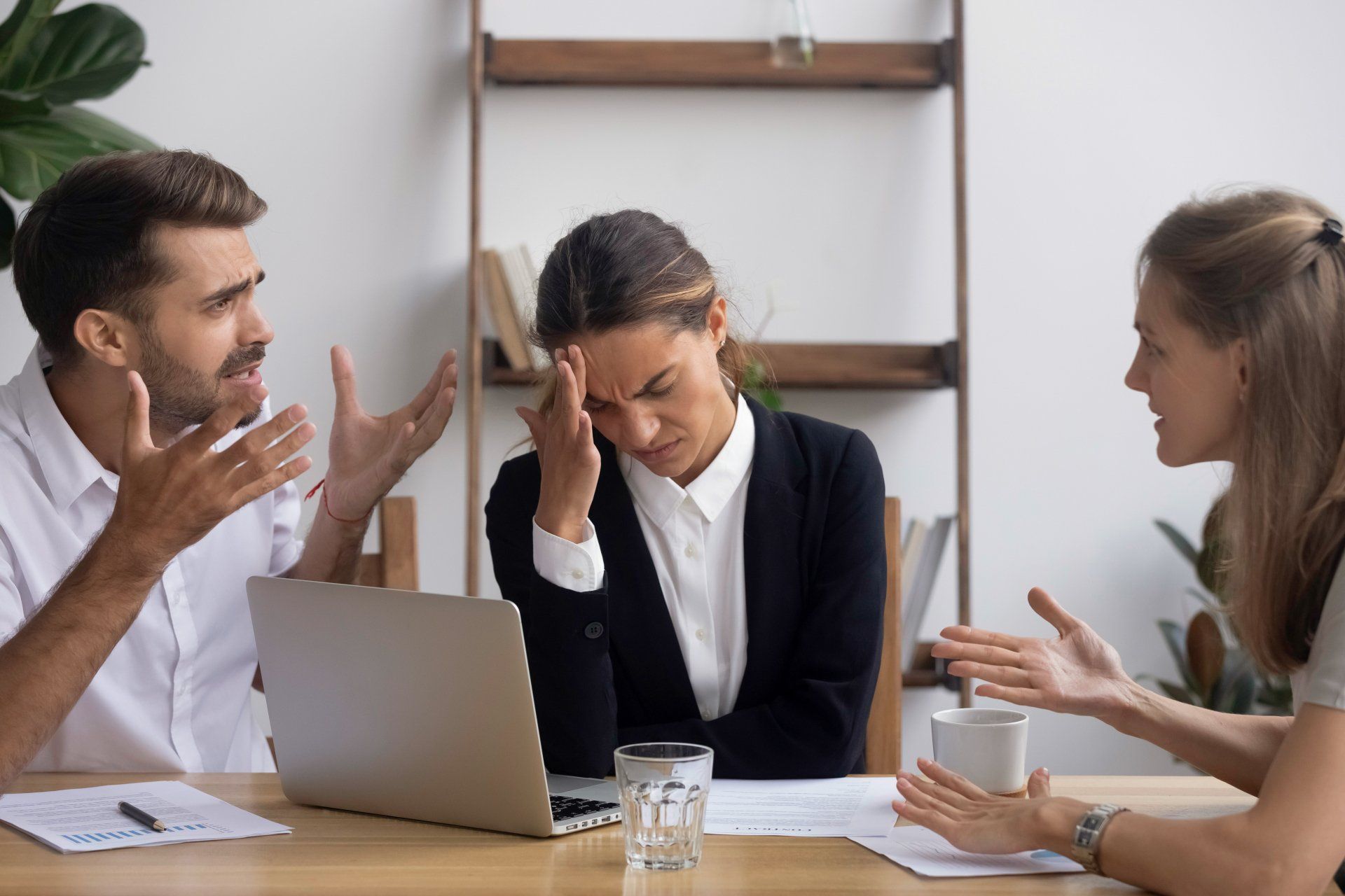 Het Mediators Collectief kan helpen bij een zakelijk conflict 1 man en 2 vrouwen in veen zakelijk conflict aan tafel met een laptop