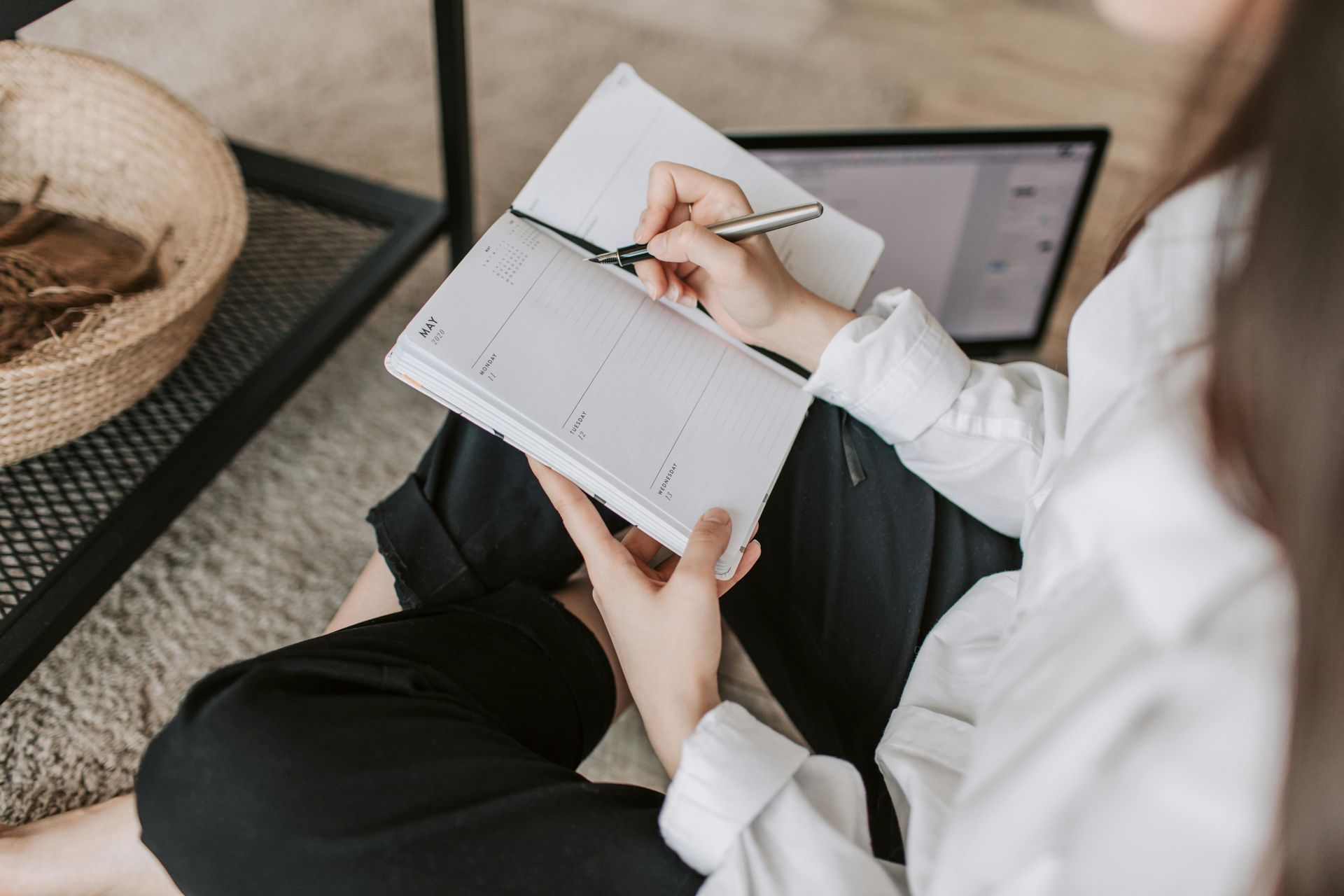 Woman sitting on the floor writing in a notebook, about way to work through anxiety and burnout.