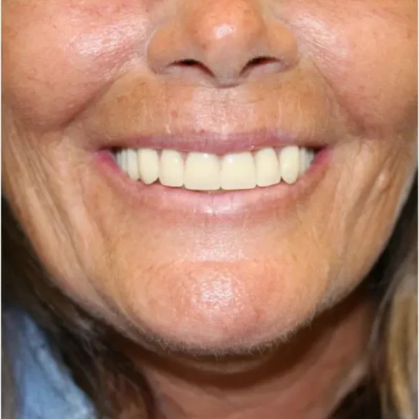 A close up of a woman 's face with a smile on her face.
