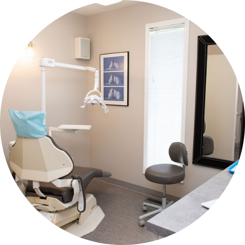 A dental office with a chair and a mirror