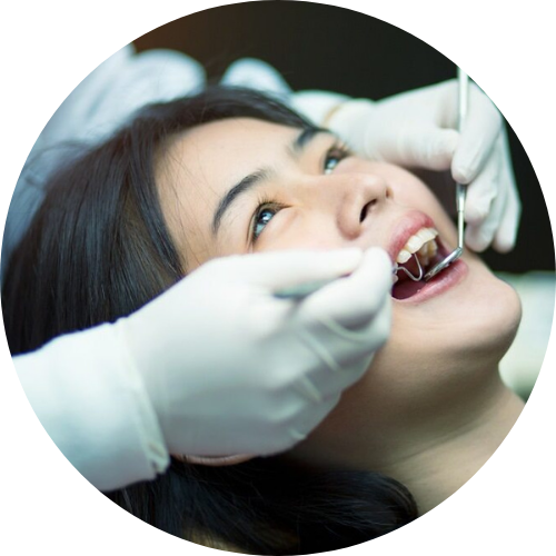A woman is getting her teeth examined by a dentist