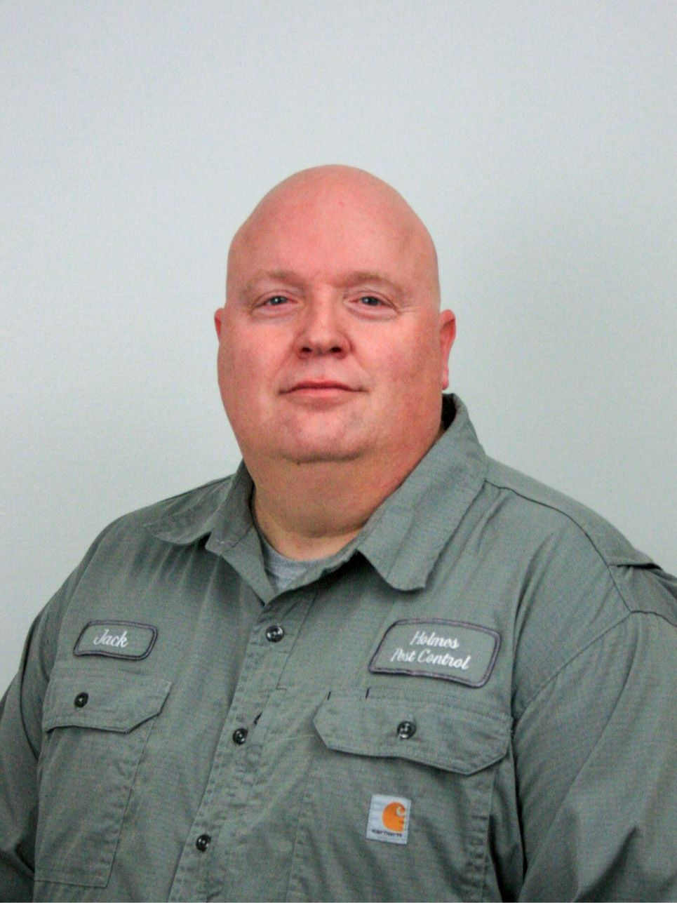 Man in gray work shirt, bald head, smiling, name tag: