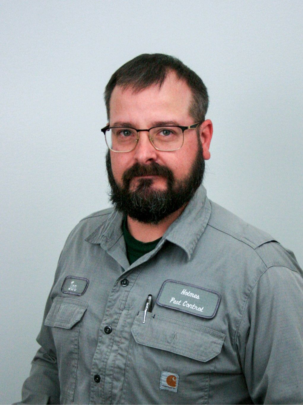 Man wearing glasses and work shirt, with name tag.