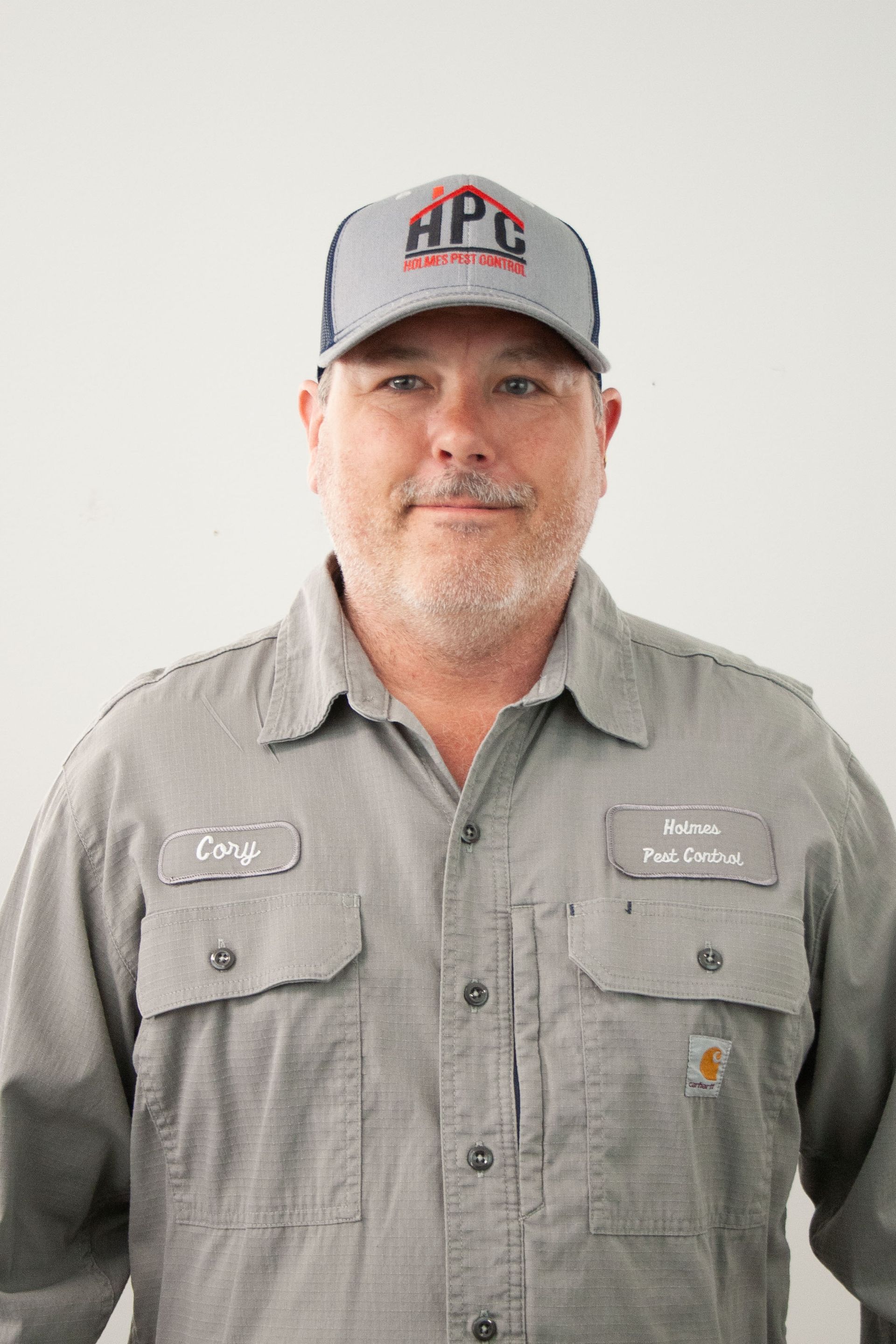 Man wearing HPC hat and work shirt smiles.