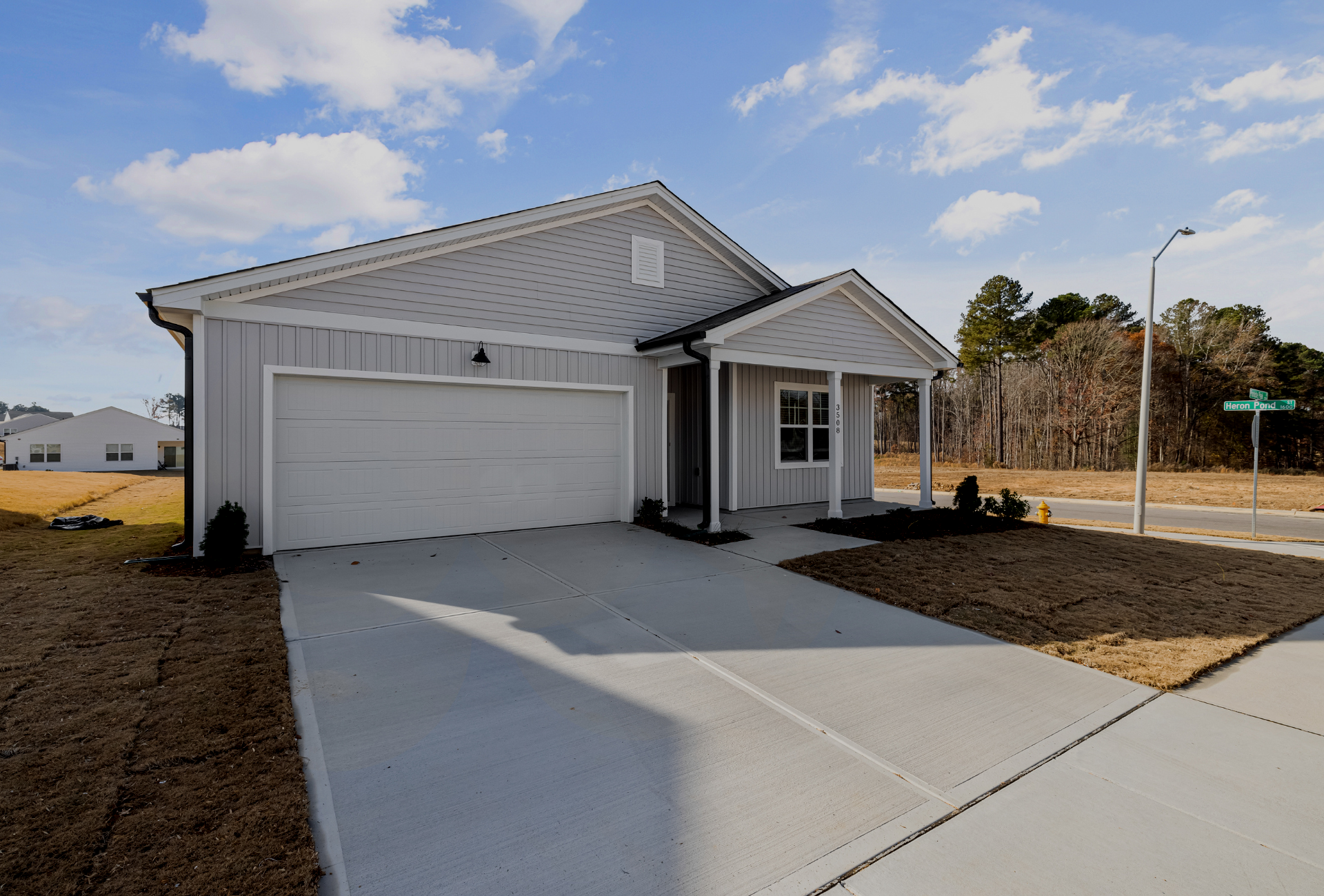A house with a garage and a driveway in front of it.