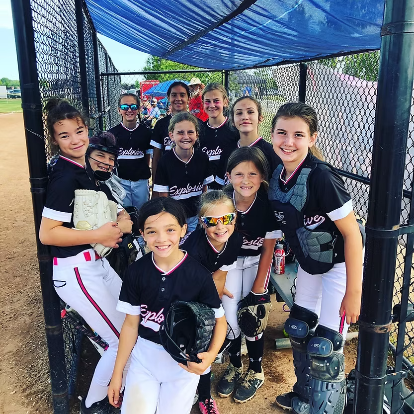 Explosive Fastpitch softball team in a dugout.