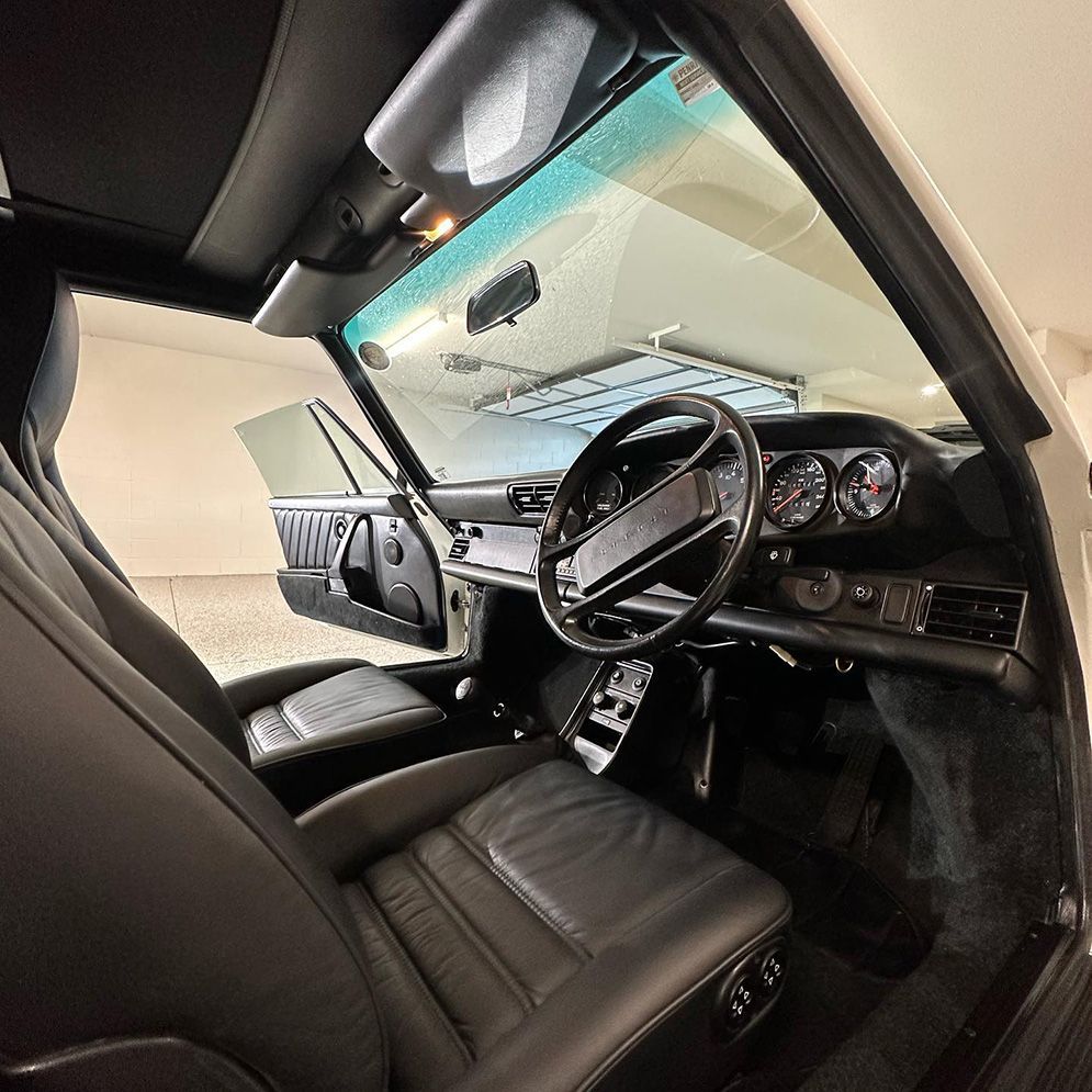 The Interior Of A White Car With The Door Open And The Steering Wheel Visible — Remedy Mobile Car Detailing in Burleigh, QLD