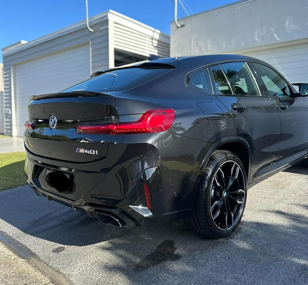 A Black Bmw X4 Is Parked In Front Of A Garage — Remedy Mobile Car Detailing in Palm Beach, QLD