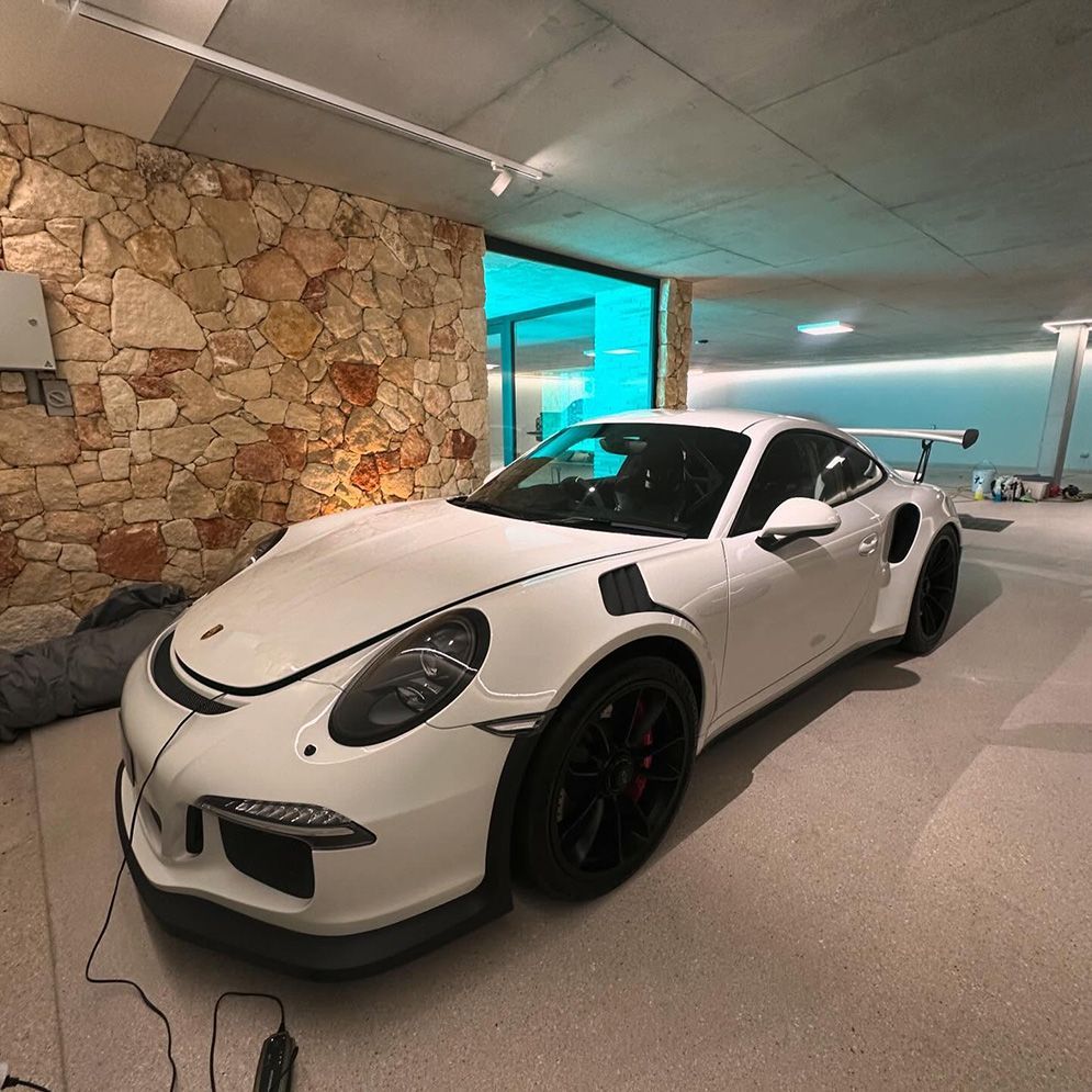 A White Sports Car Is Parked In A Garage Next To A Stone Wall — Remedy Mobile Car Detailing in Currumbin, QLD