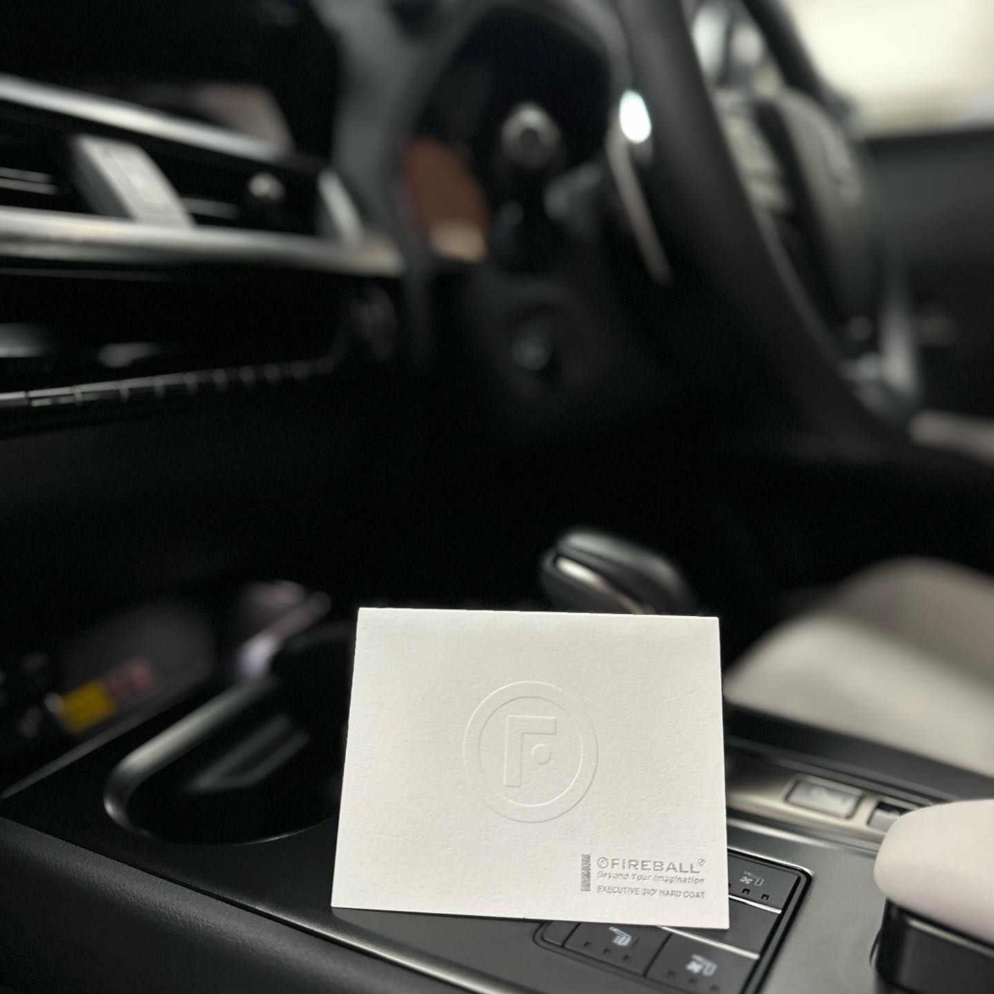 White Card With Embossed Logo In A Car's Center Console — Remedy Mobile Car Detailing in Currumbin, QLD