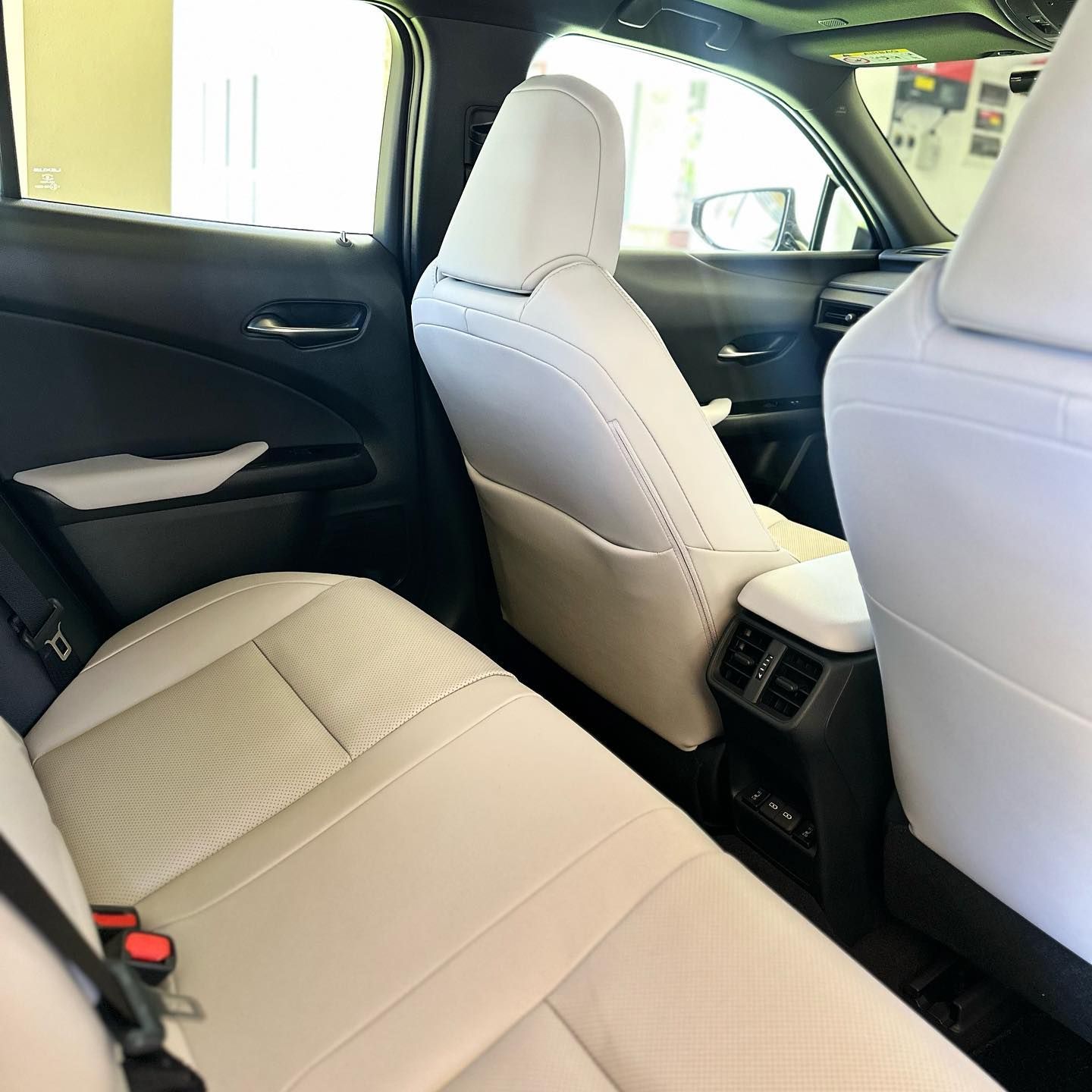 The Back Seat Of A Car With White Seats And Red Seat Belts — Remedy Mobile Car Detailing in Tweed Heads, NSW