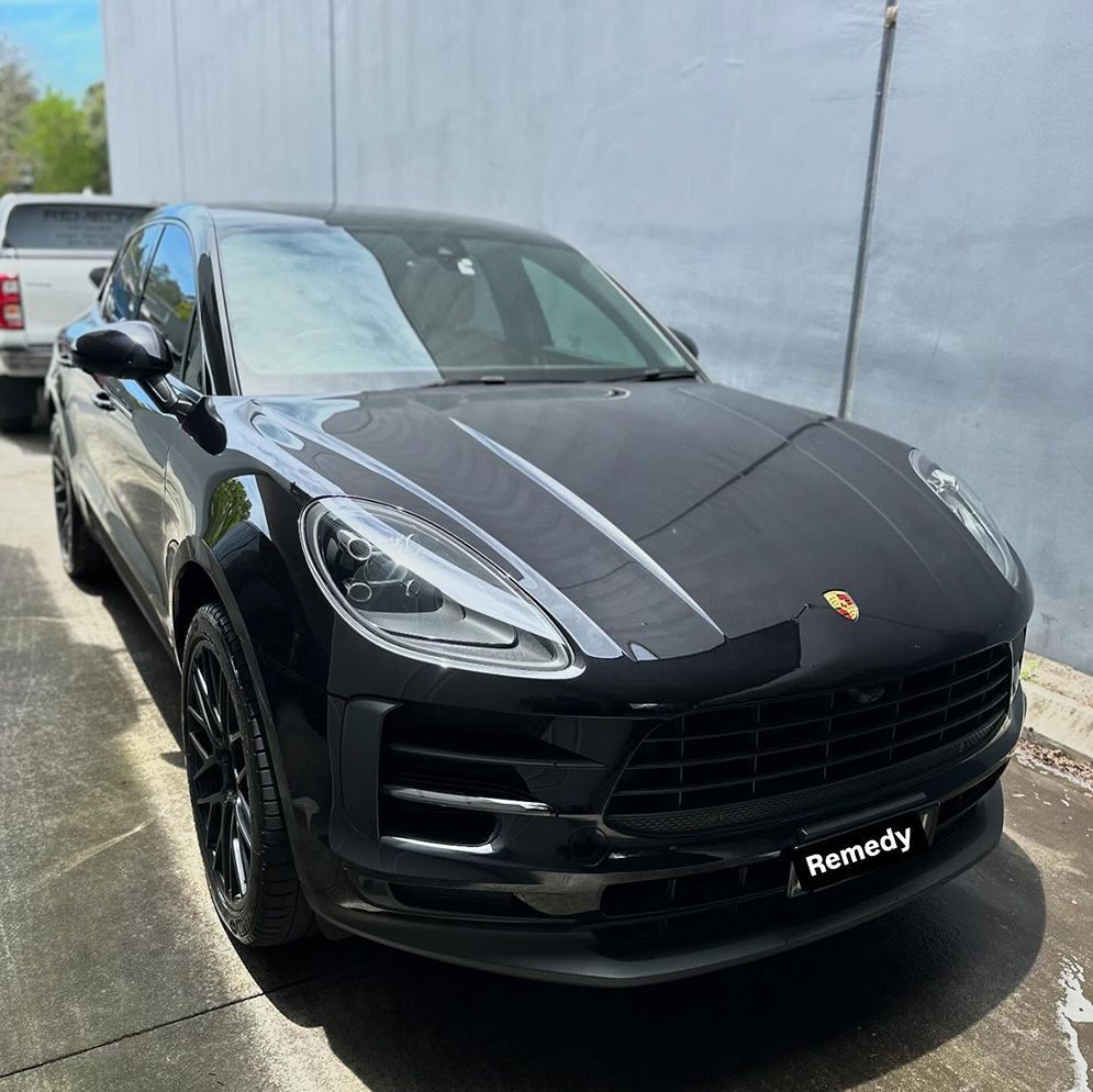 A Black Porsche Macan Is Parked In Front Of A Building — Remedy Mobile Car Detailing in Tweed Heads, NSW