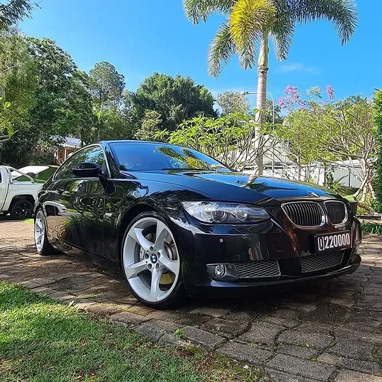 A Black Bmw 3 Series Coupe Is Parked In A Driveway Next To A Palm Tree — Remedy Mobile Car Detailing in Gold Coast, QLD