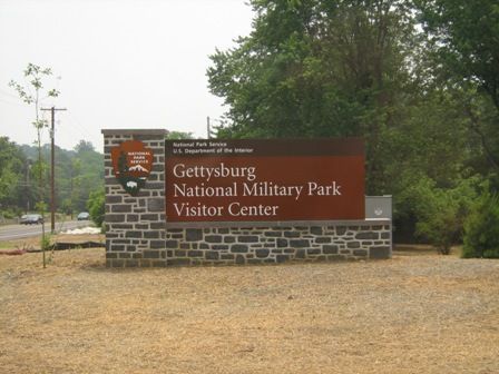 Sign for Gettysburg National Military Park Visitor Center, brown and stone construction.