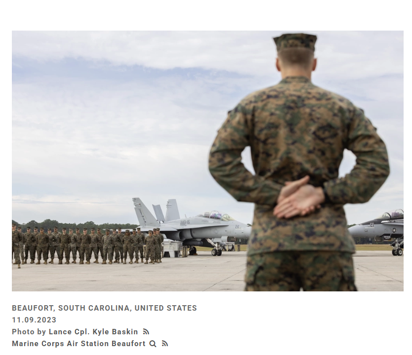 Marine in uniform watches assembled Marines and fighter jets at Beaufort, SC.