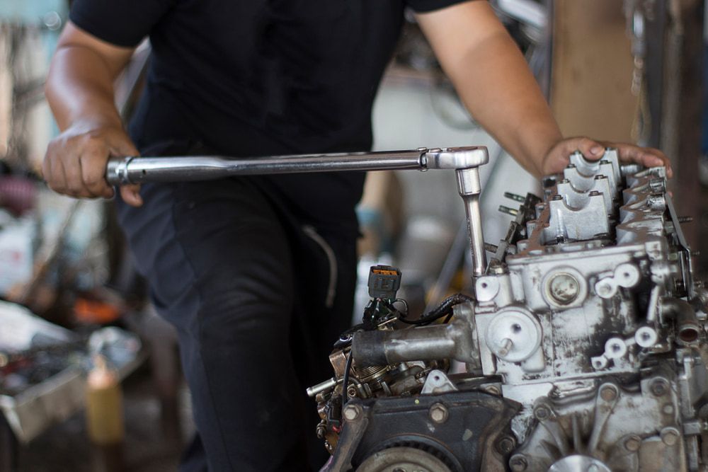 A Man is Working on a Car Engine With a Wrench — ANI Automotive in Long Jetty, NSW