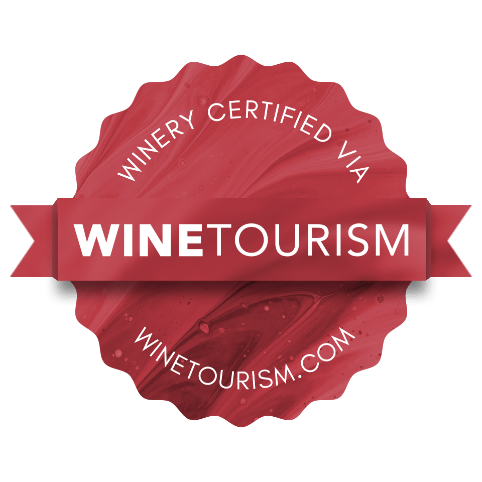 Una bodega certificada mediante logo de enoturismo con lazo rojo