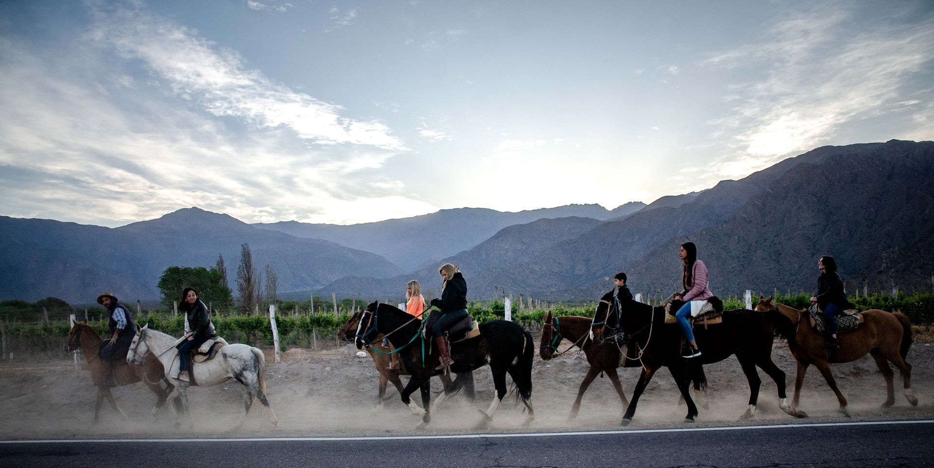 Un grupo de personas van a caballo por un camino.