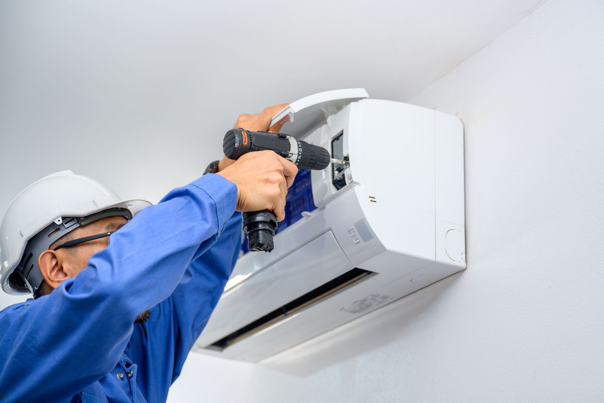 A technician performs AC repair in a residential house.